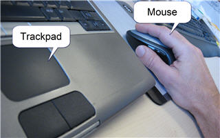 Trackpad on a laptop and mouse next to it